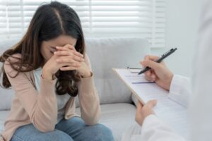 A woman with mental health concerns consults a psychiatrist, who documents her condition to develop a treatment plan. 