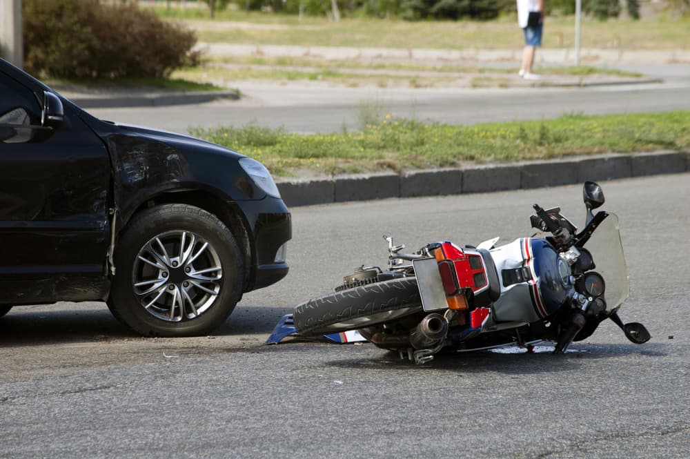 Motorcycle and car collision on the road.