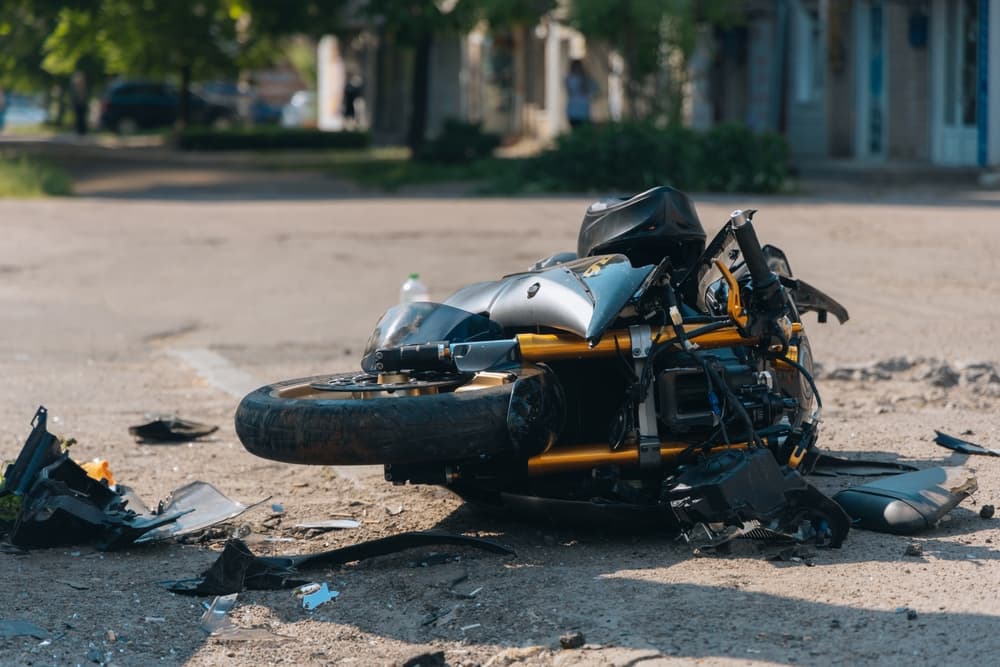 The motorcycle lies on the road after the collision.