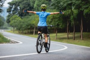 Riding a bike without hands in the park.