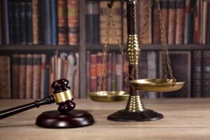 A judge's gavel, scales of justice, and law books in a courtroom.