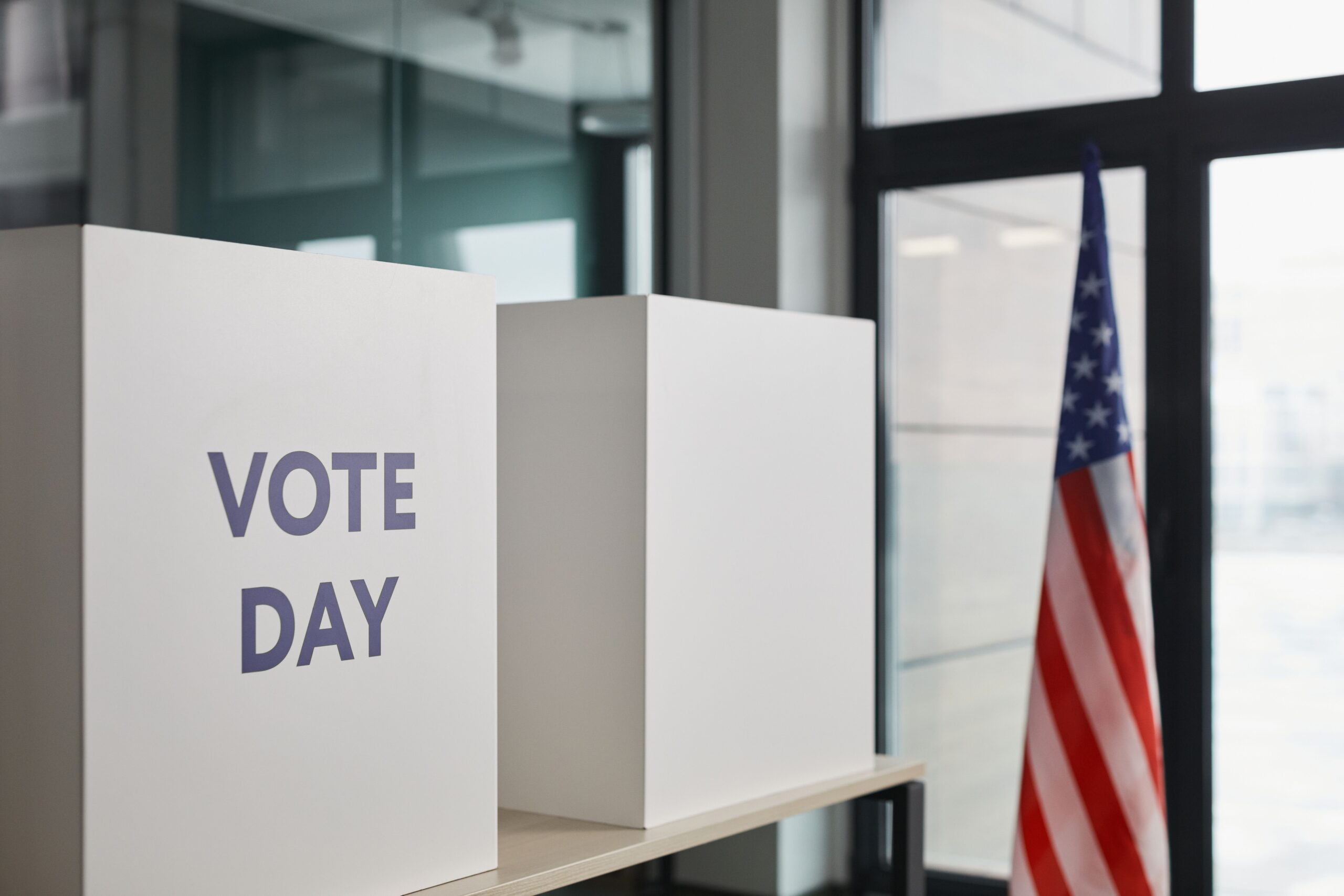 Voting booths and an American flag at a polling location, representing Election Day and road rage accident awareness in Atlanta, Georgia.